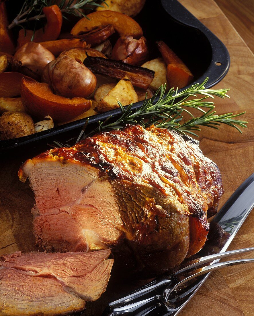 Roast leg of lamb, slices cut, by roasting dish with vegetables