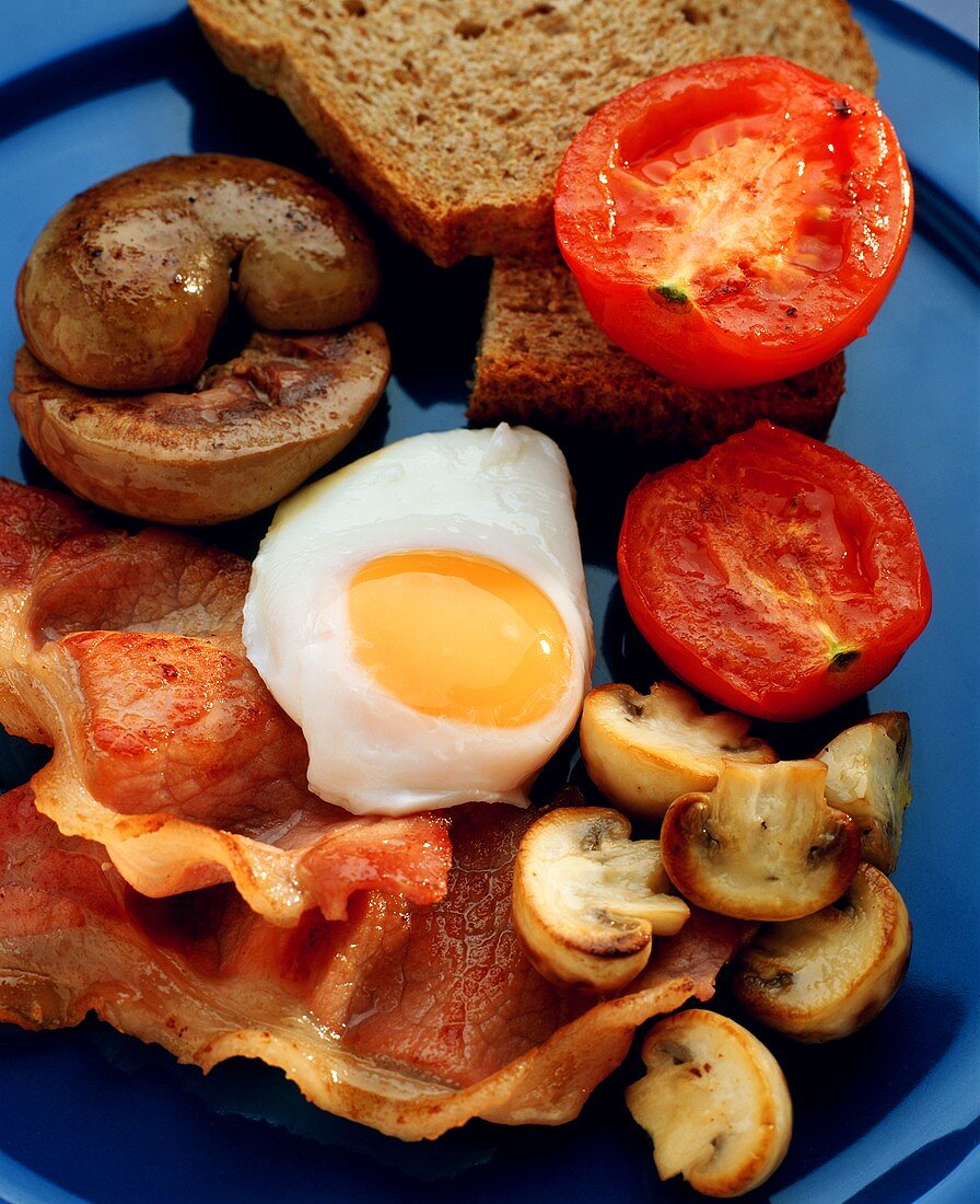 Fried egg, bacon, mushrooms & tomatoes with bread