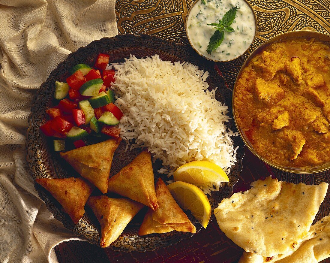 Indische Teigtaschen mit Reis; Eintopf; Dip und Fladenbrot