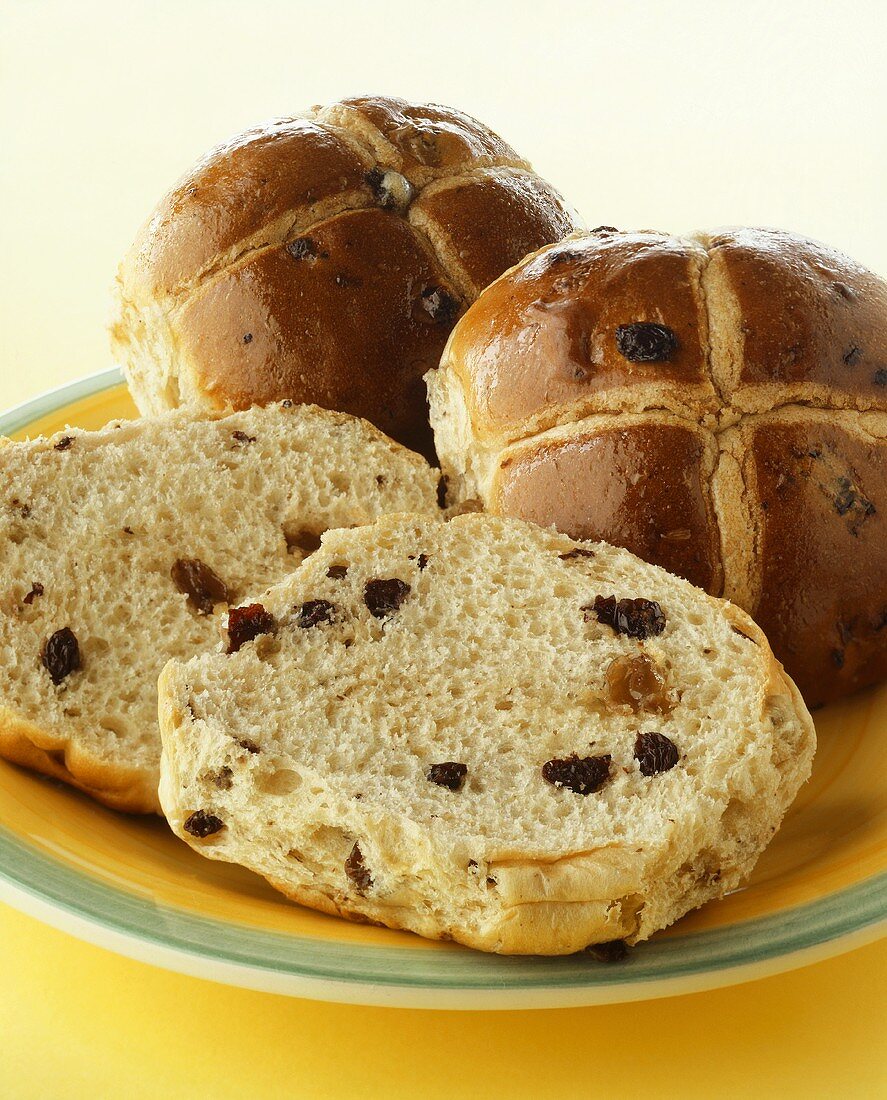 Rosinenbrötchen, eines halbiert, auf Teller