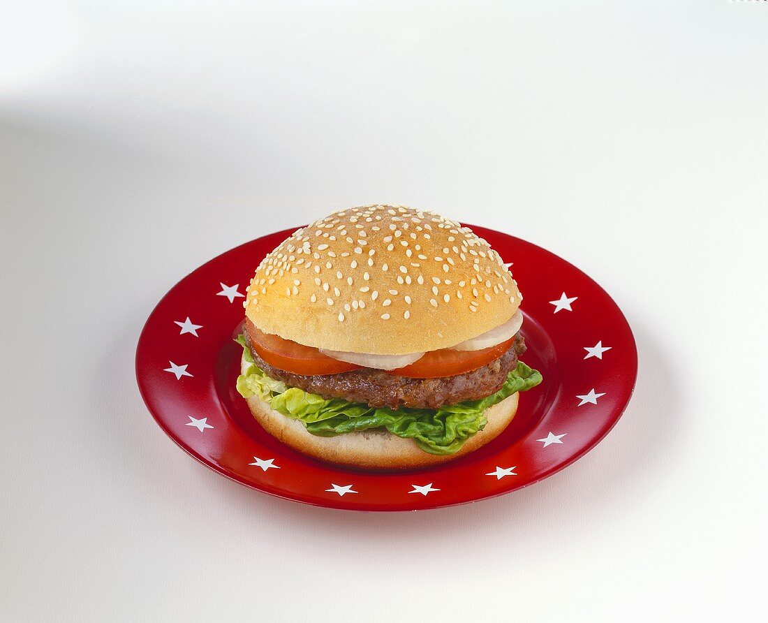 Ein Hamburger auf rotem Teller mit weissen Sternchen