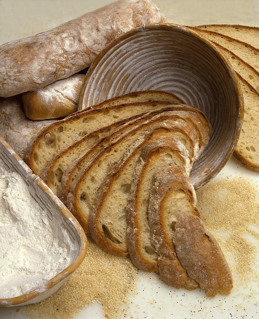 Italienisches Brot: Brotscheiben in Schale, Mehl, Sesamsamen