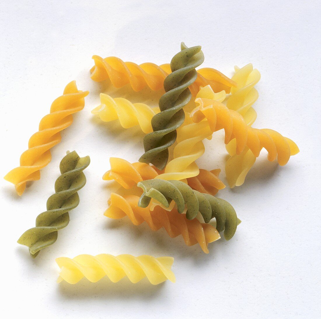 Mixed pasta spirals (Eliche) on a grey background