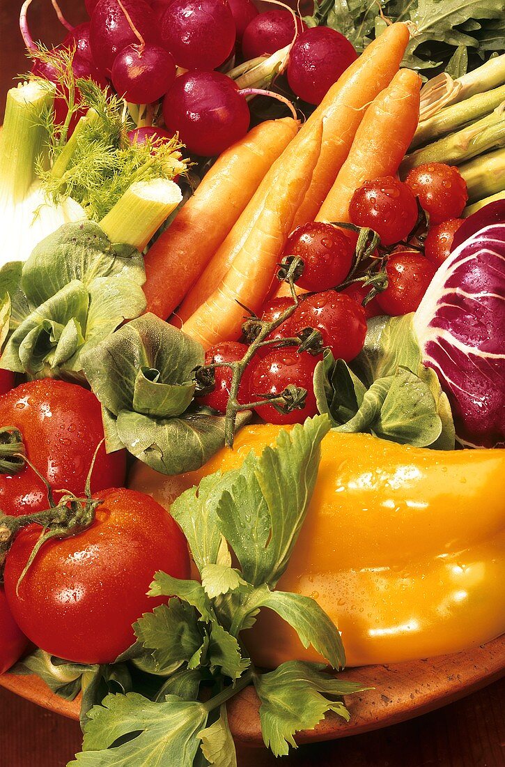 Frische Gemüsesorten in Holzschüssel, z.B. Möhren, Tomaten