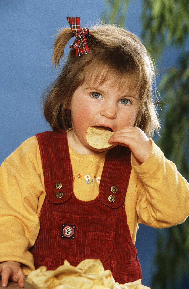 Kleines Mädchen isst Kartoffelchip