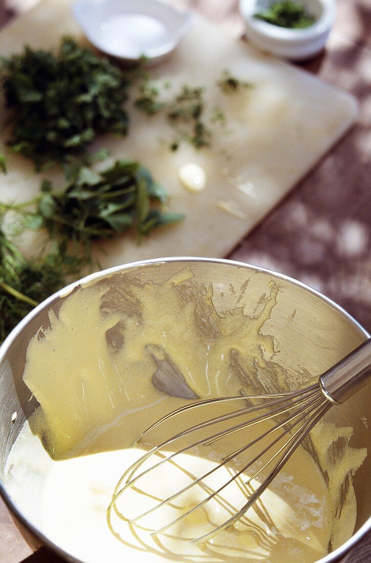 Making fresh mayonnaise; herbs on chopping board