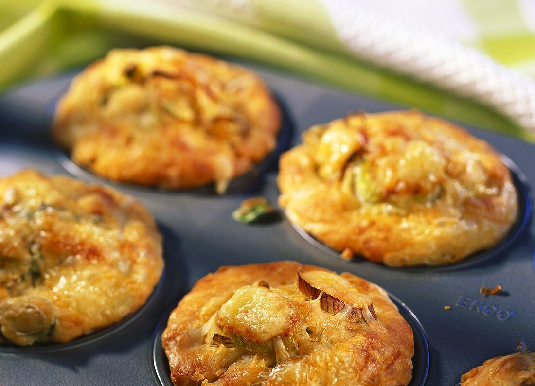 Four leek and cheese muffins in muffin tin
