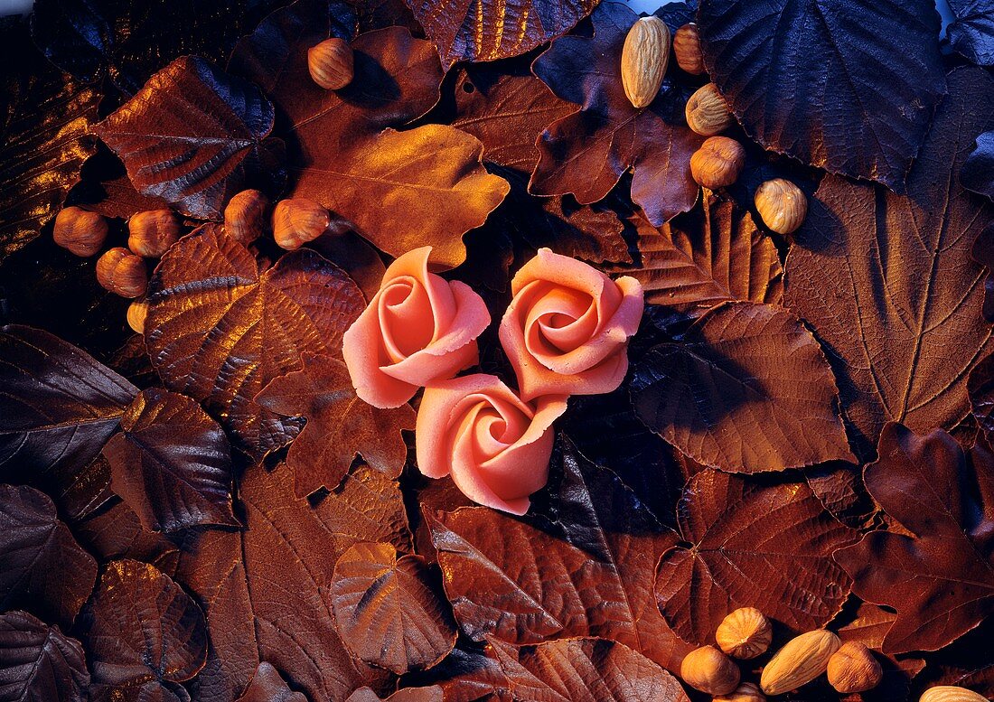 Still life with marzipan roses, chocolate leaves and nuts