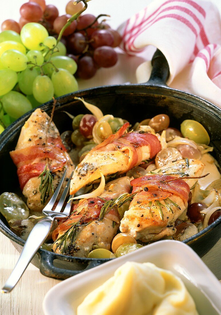 Braised chicken breast with grapes and bacon in pan