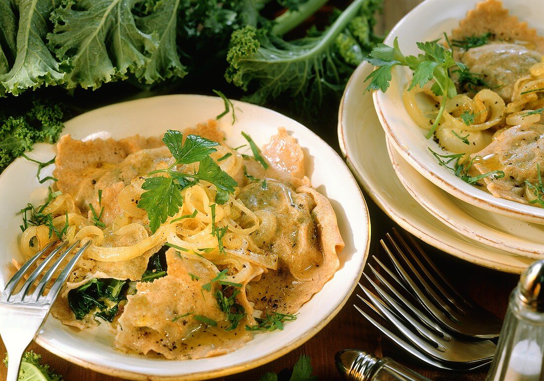 Maultaschen mit Grünkohl und Zwiebeln auf Tellern