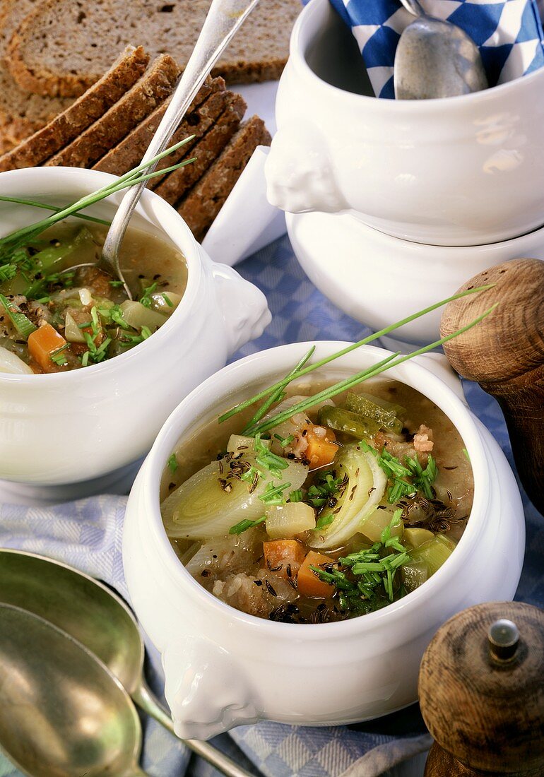 Brotsuppe mit Gemüse und Speck in kleinen Suppenterrinen