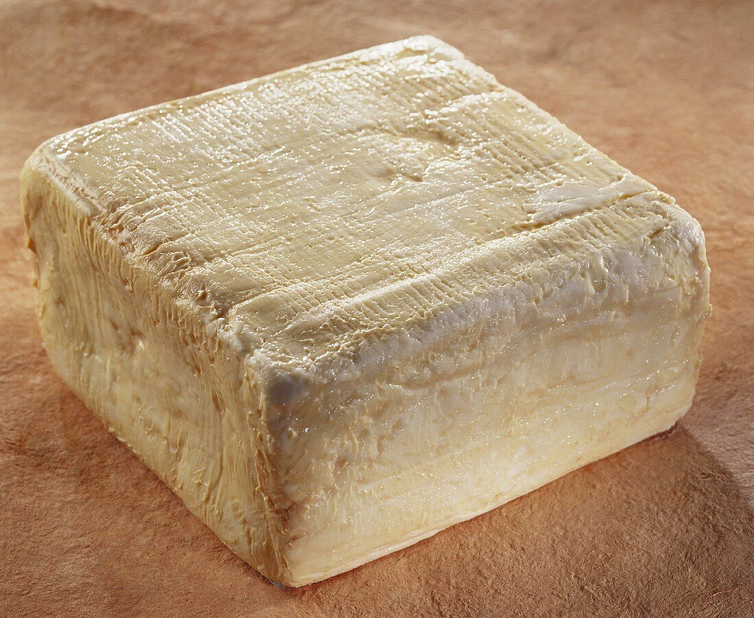 Französischer Käse Gris de Lille auf braunem Untergrund