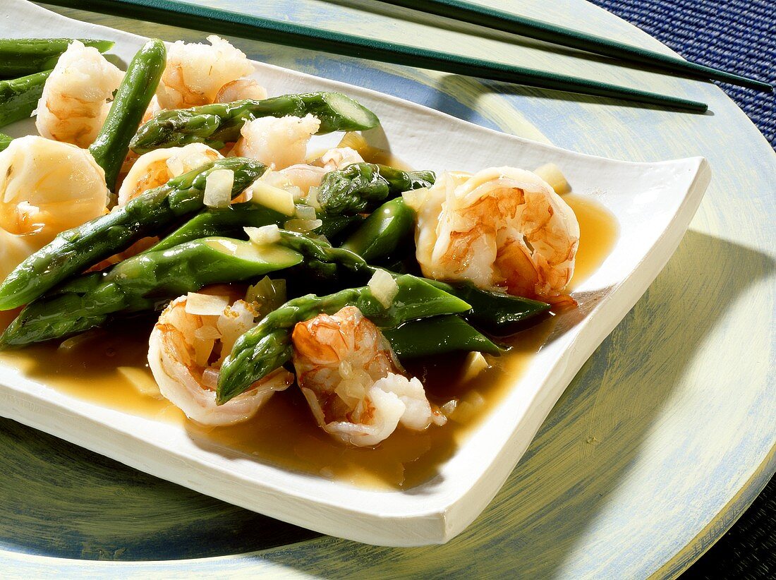 Green asparagus with scampi on a white platter