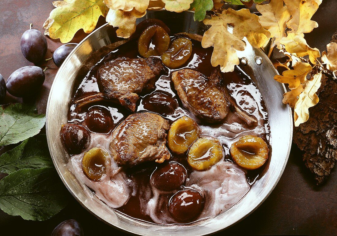 Venison cutlets with plum sauce and cream in a pan