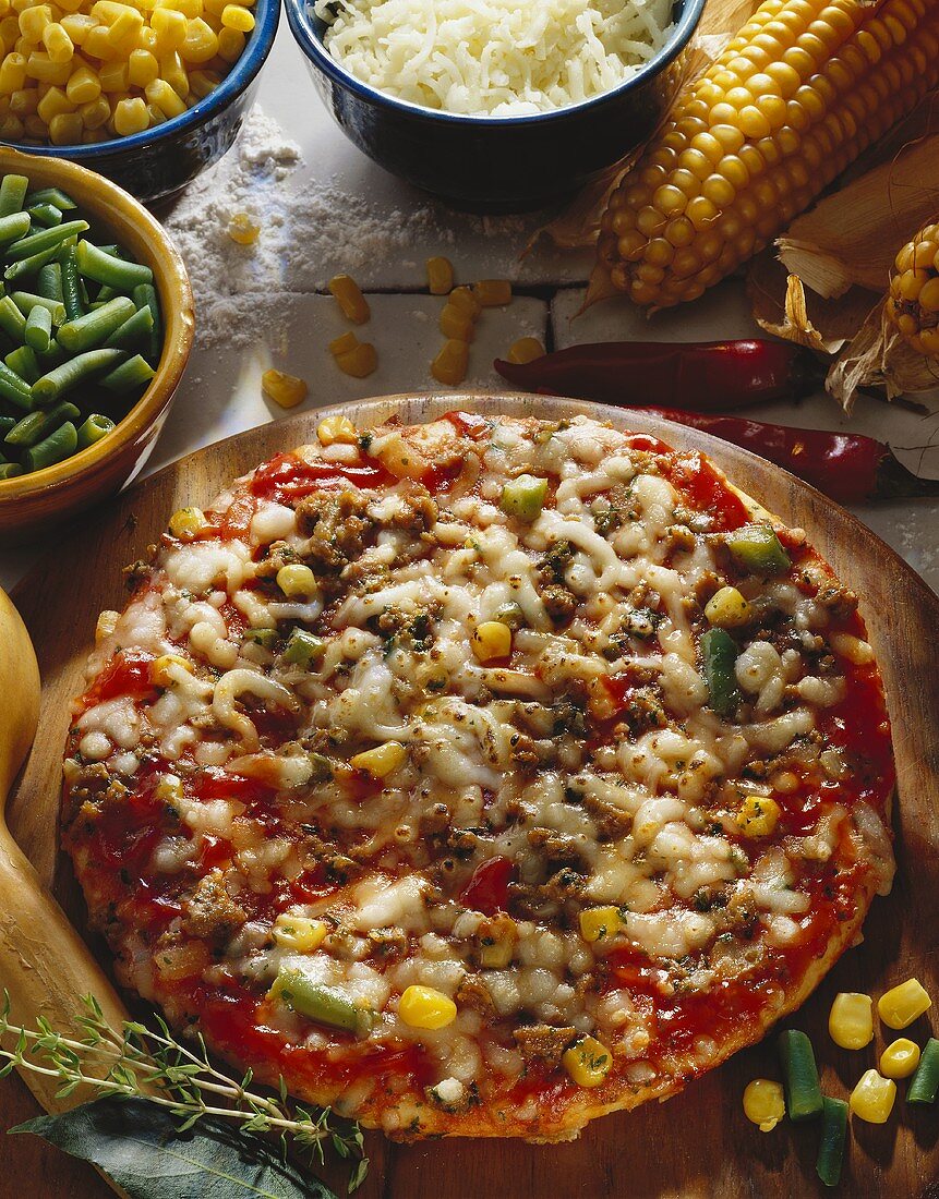 Pizza with sweetcorn and green beans on wooden plate