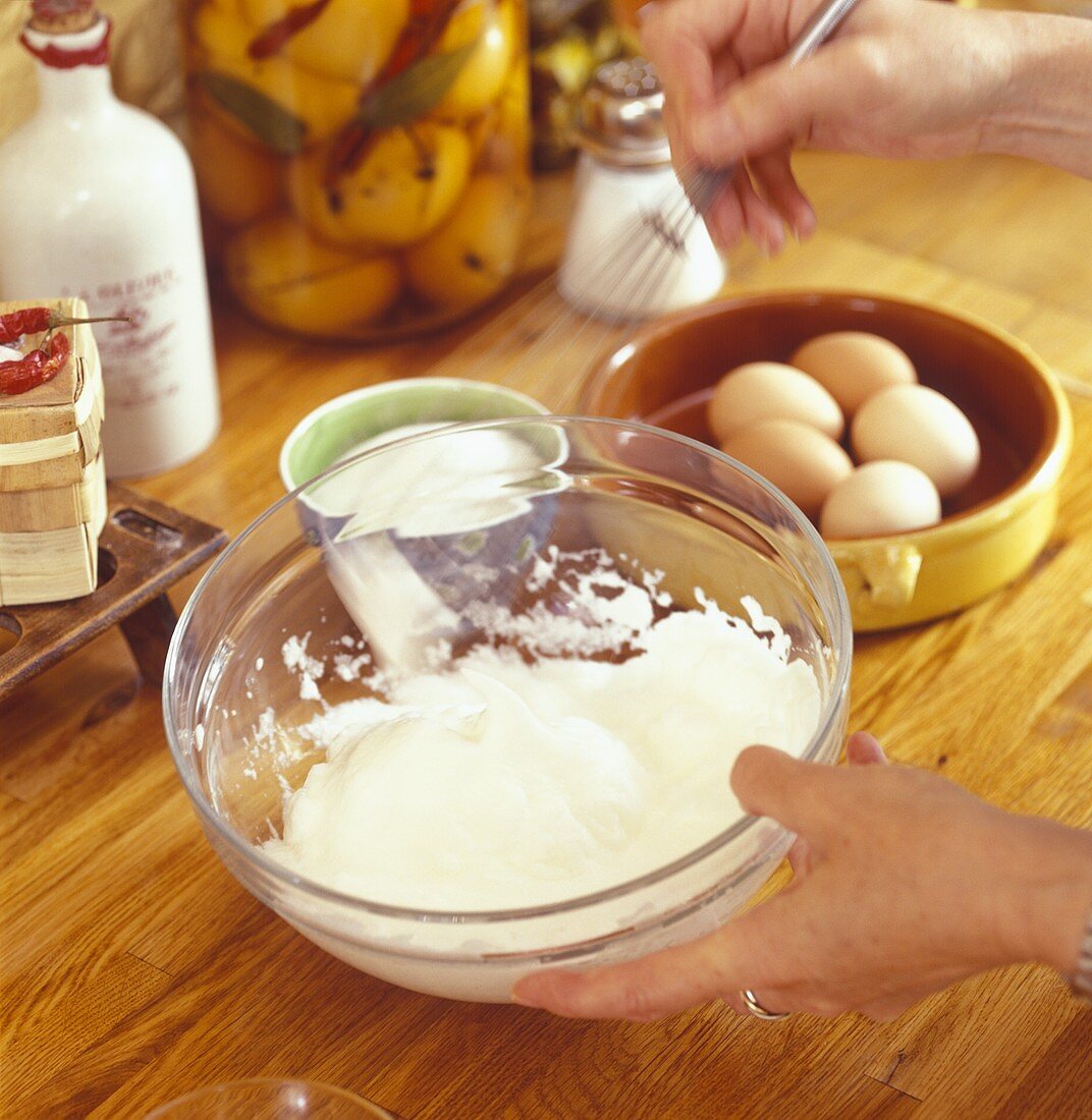 Whipping cream with whisk in a bowl