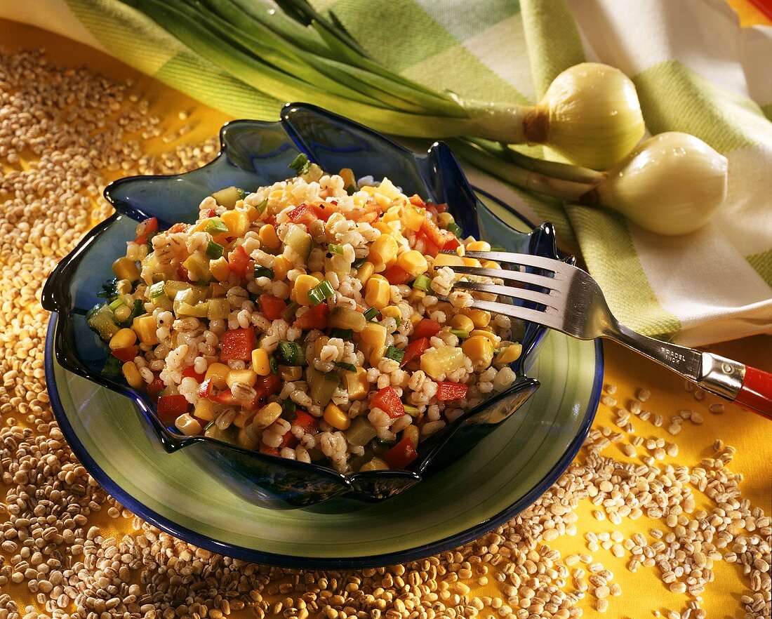 Pearl barley salad with vegetables on plate with fork