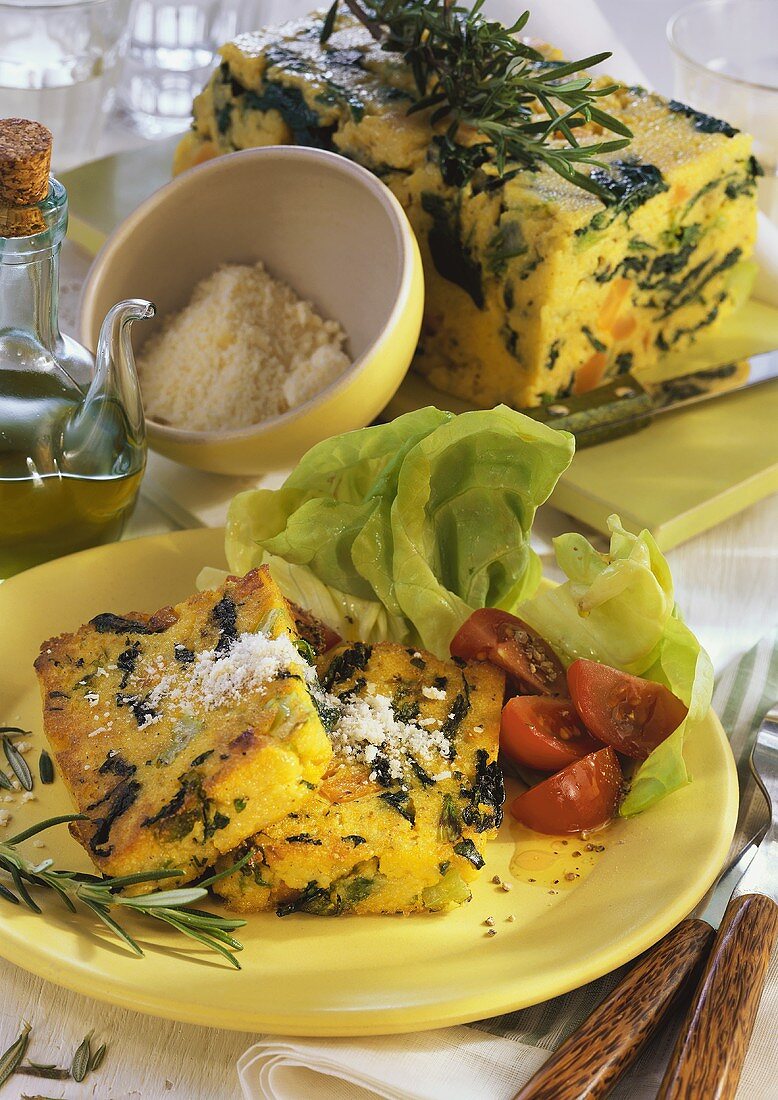 Gemüse-Polenta mit geriebenem Käse und Salat