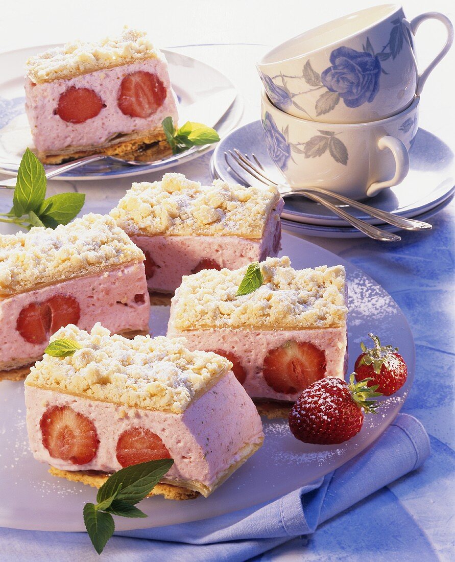 Strawberry and Prosecco cream cakes on a plate; coffee cups