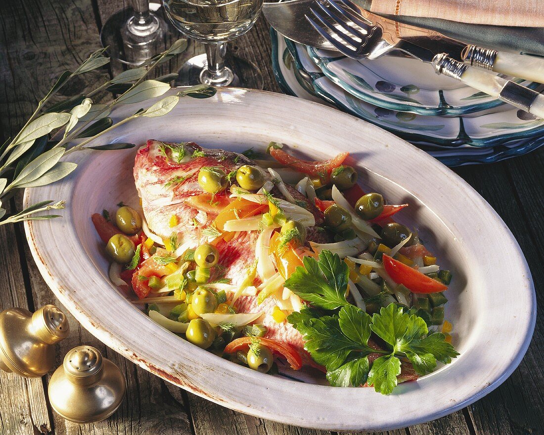 Gilthead bream with vegetables, baked in parchment, on platter