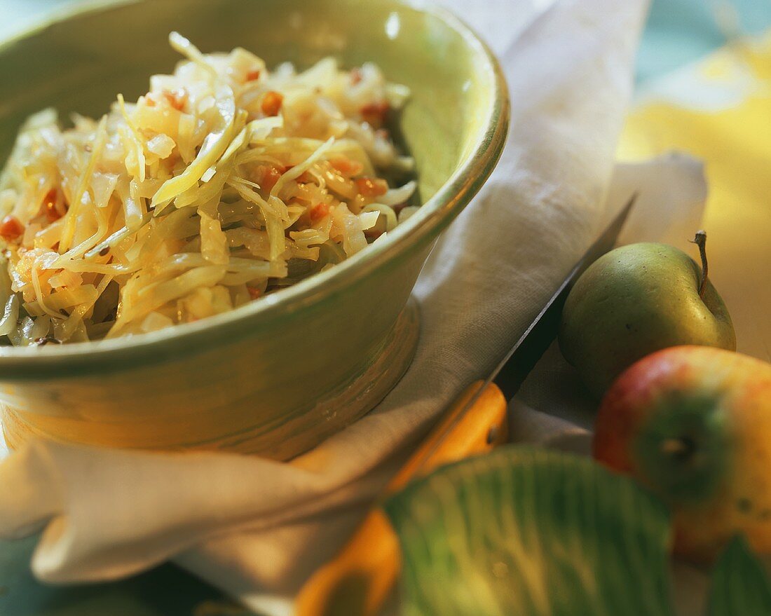 Bavarian cabbage with bacon and apples in green dish