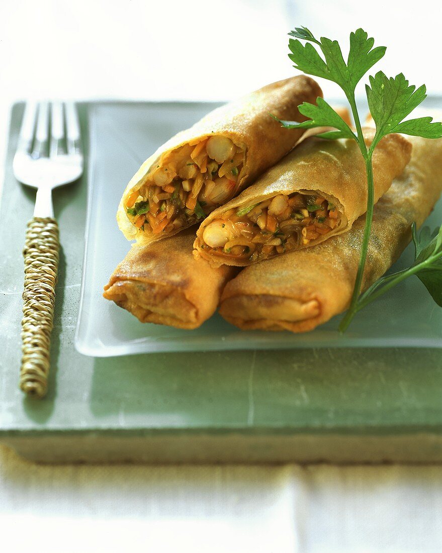 Spring rolls with shrimps; sprig of parsley