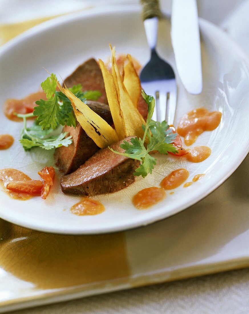 Sweet and sour lamb fillet with ginger on plate with cutlery