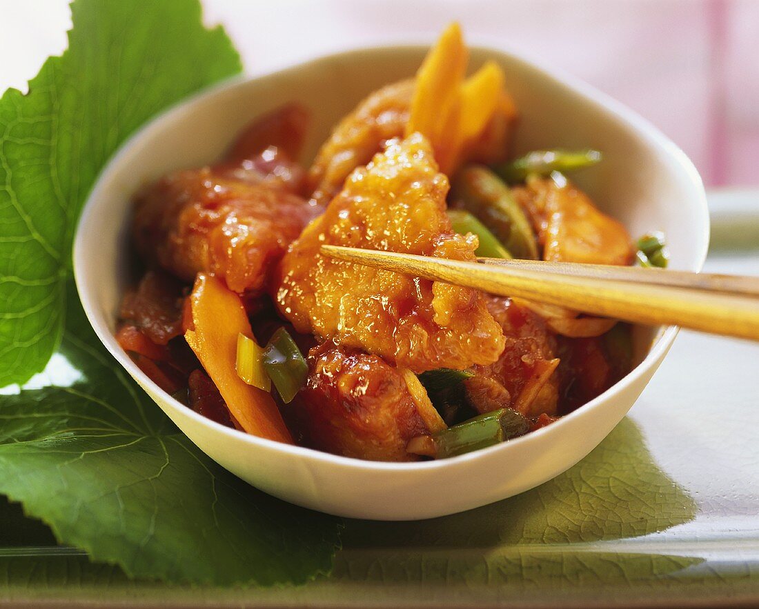 Marinated fried chicken fillet with vegetables in bowl