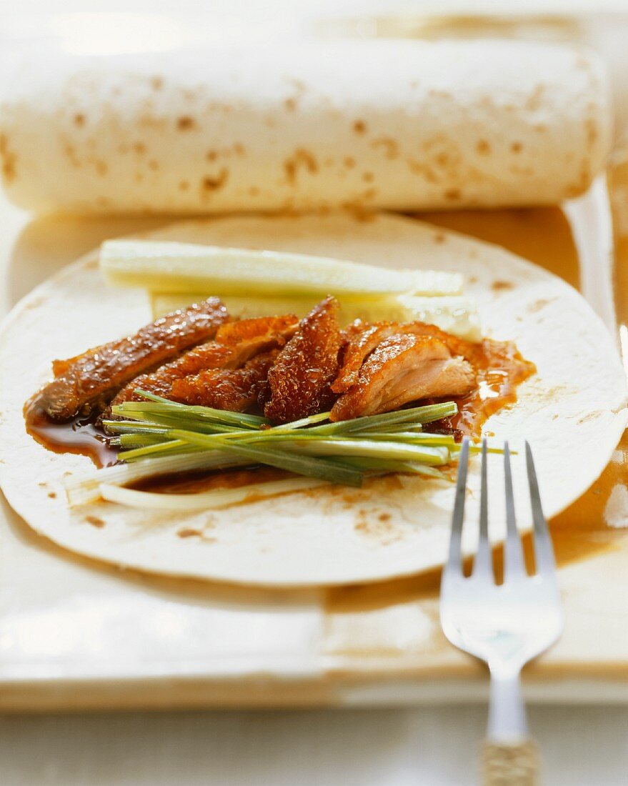 Peking duck with spring onions on pancakes