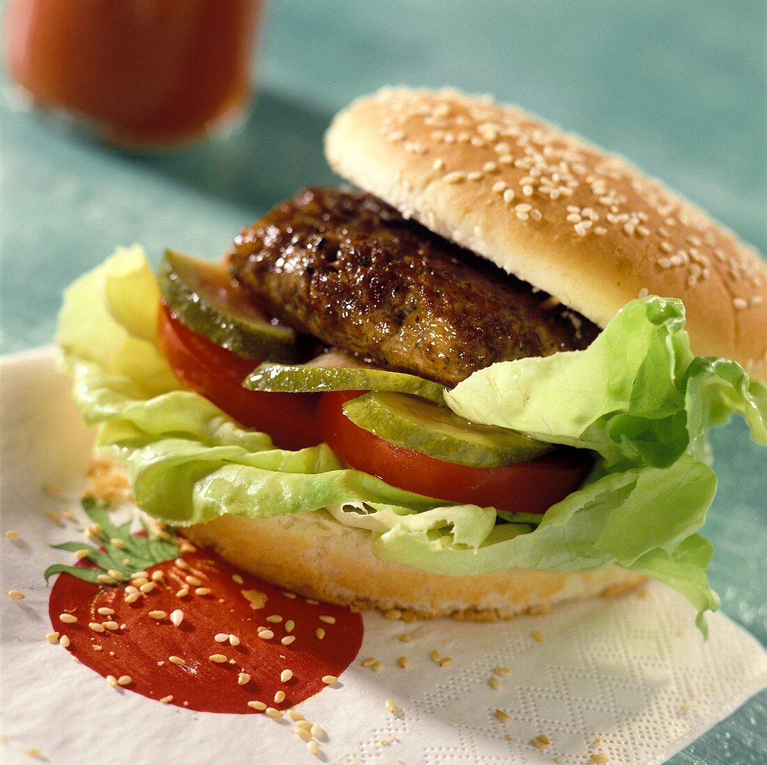 Hamburger with tomatoes, gherkin, lettuce on a napkin