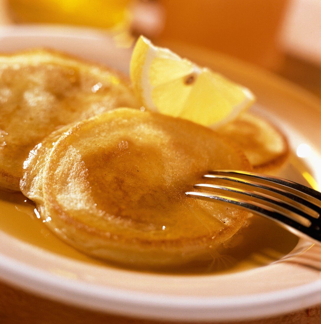 Pancakes with maple syrup and lemon wedge