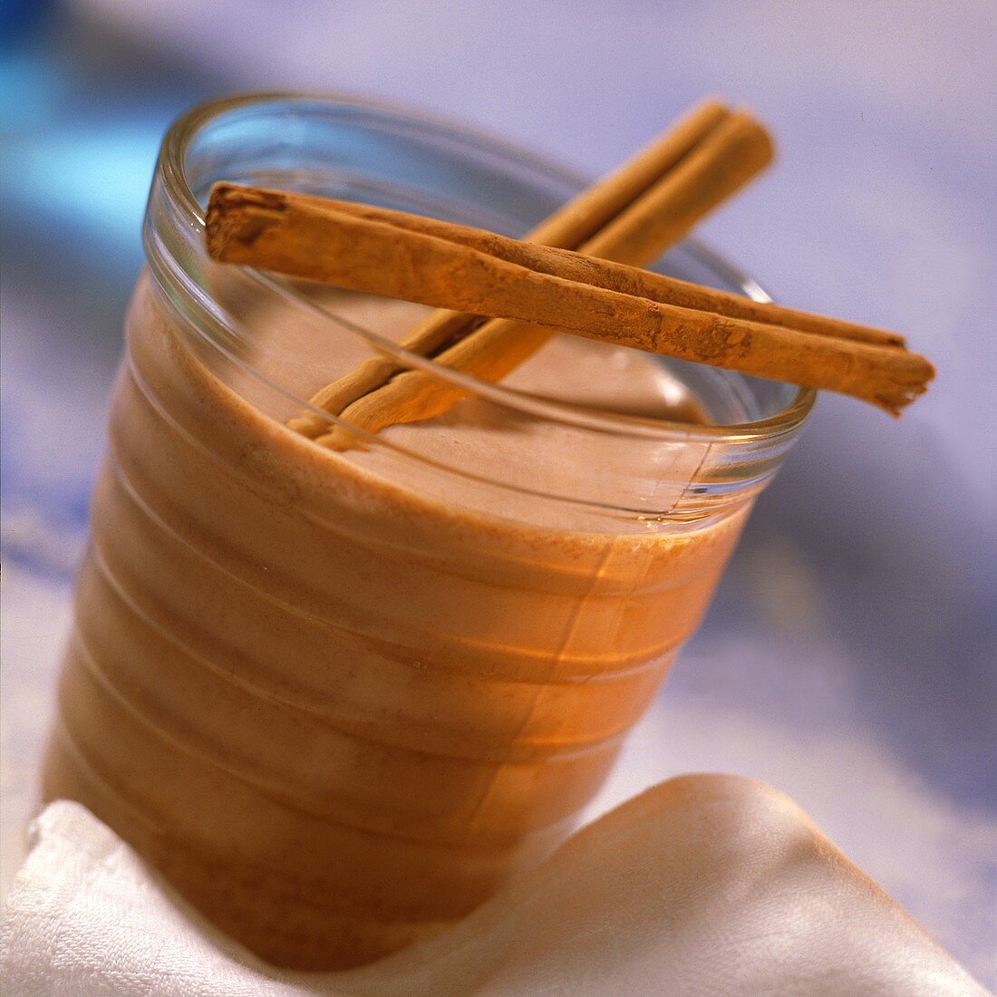 Hot chocolate in a glass with cinnamon sticks