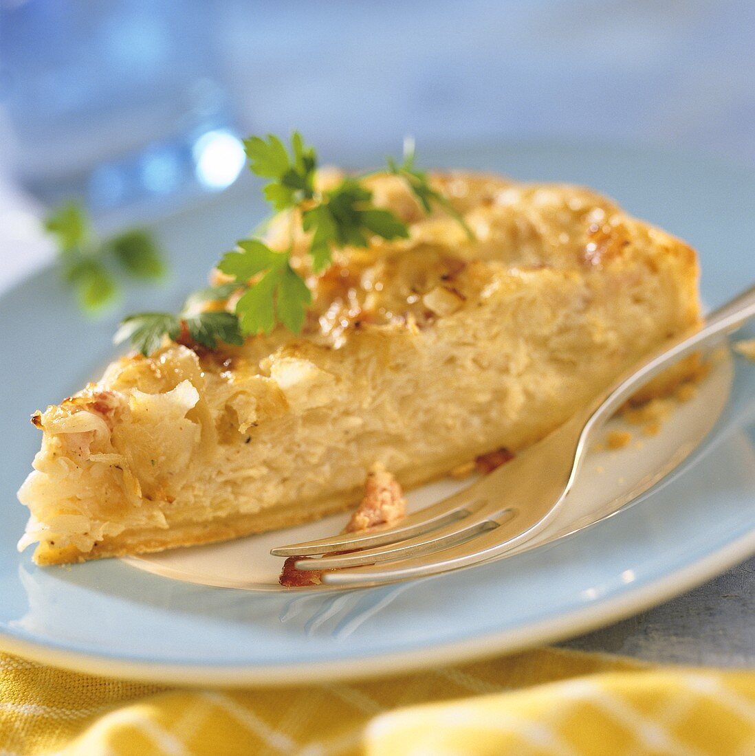 A piece of sauerkraut quiche with parsley on plate