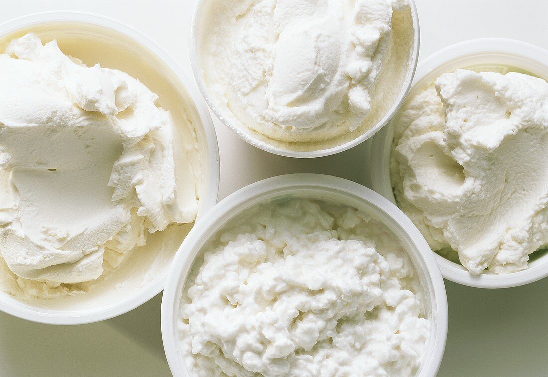 Various types of cream cheese and cottage cheese in bowls