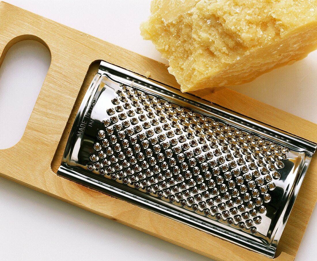 A piece of parmesan with hand grater