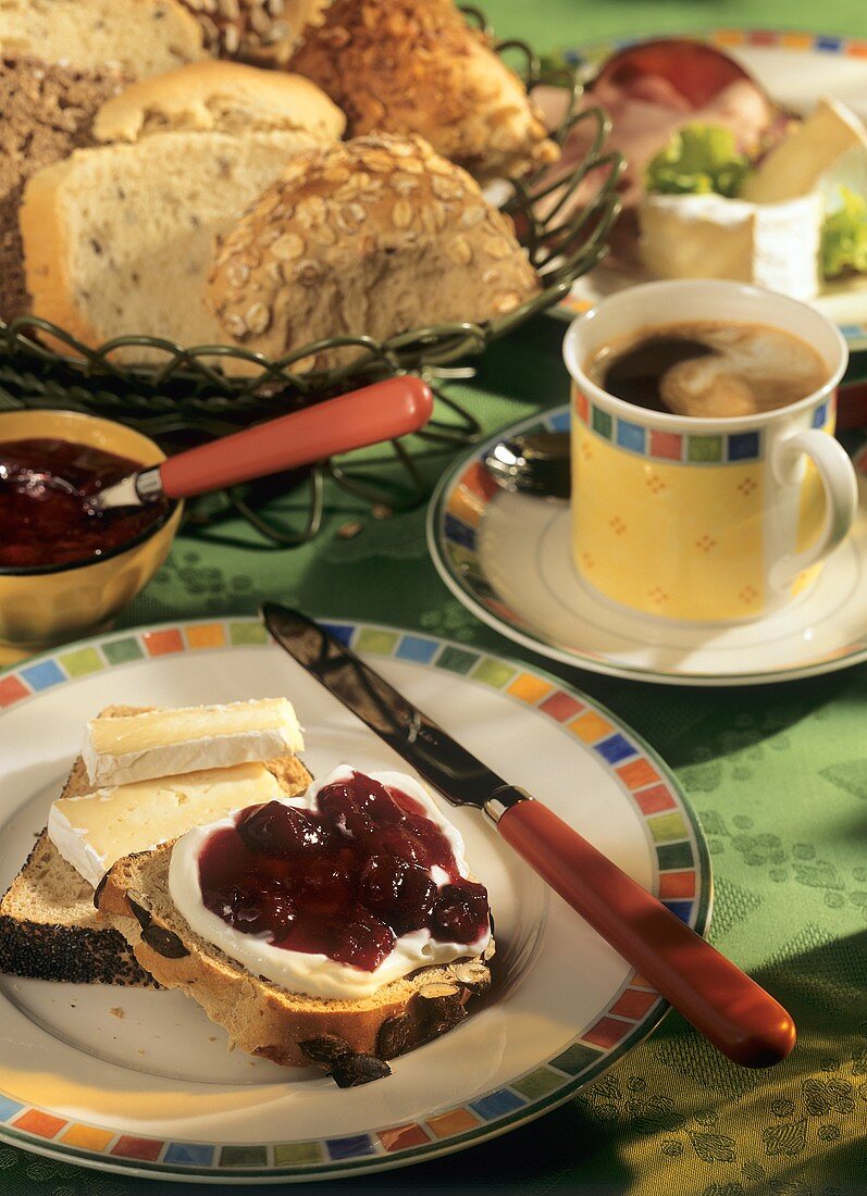Frühstück mit Marmeladen- und Käsebrot, Kaffee, Brotkorb