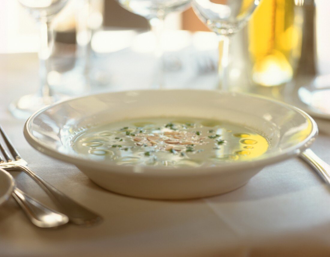 A plate of grape soup on laid table