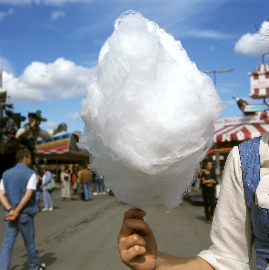 Frau hält Zuckerwatte in der Hand am Oktoberfest