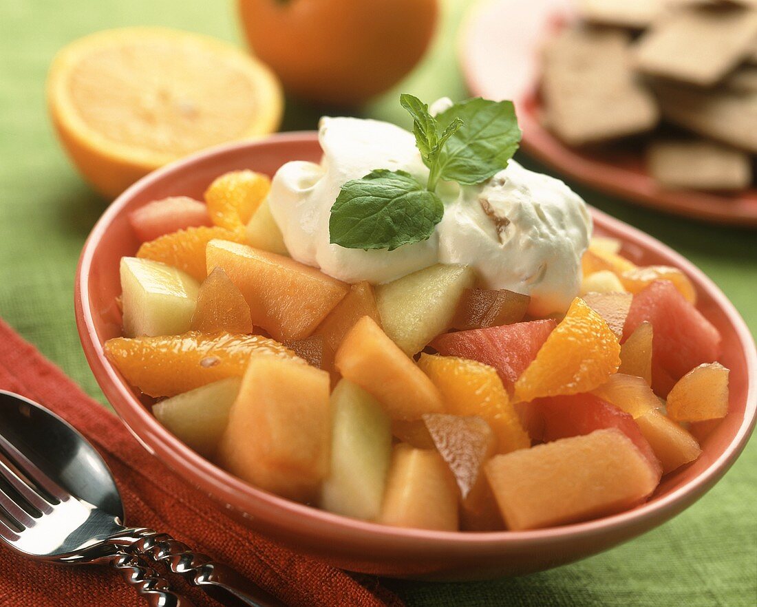 Fruchtsalat mit Sahne in rotem Schälchen