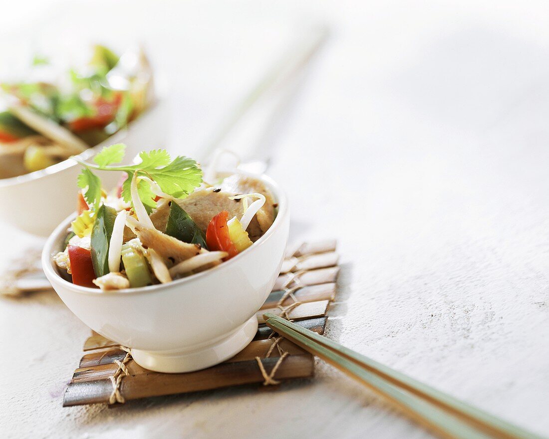 Asian chicken and sprout stir-fry in white bowl