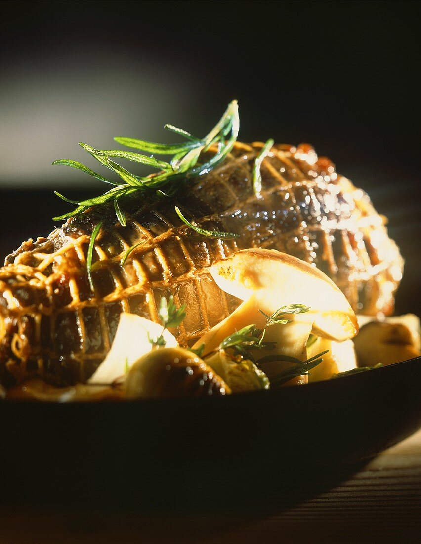 Roast venison roll with tarragon & onions in roasting tin