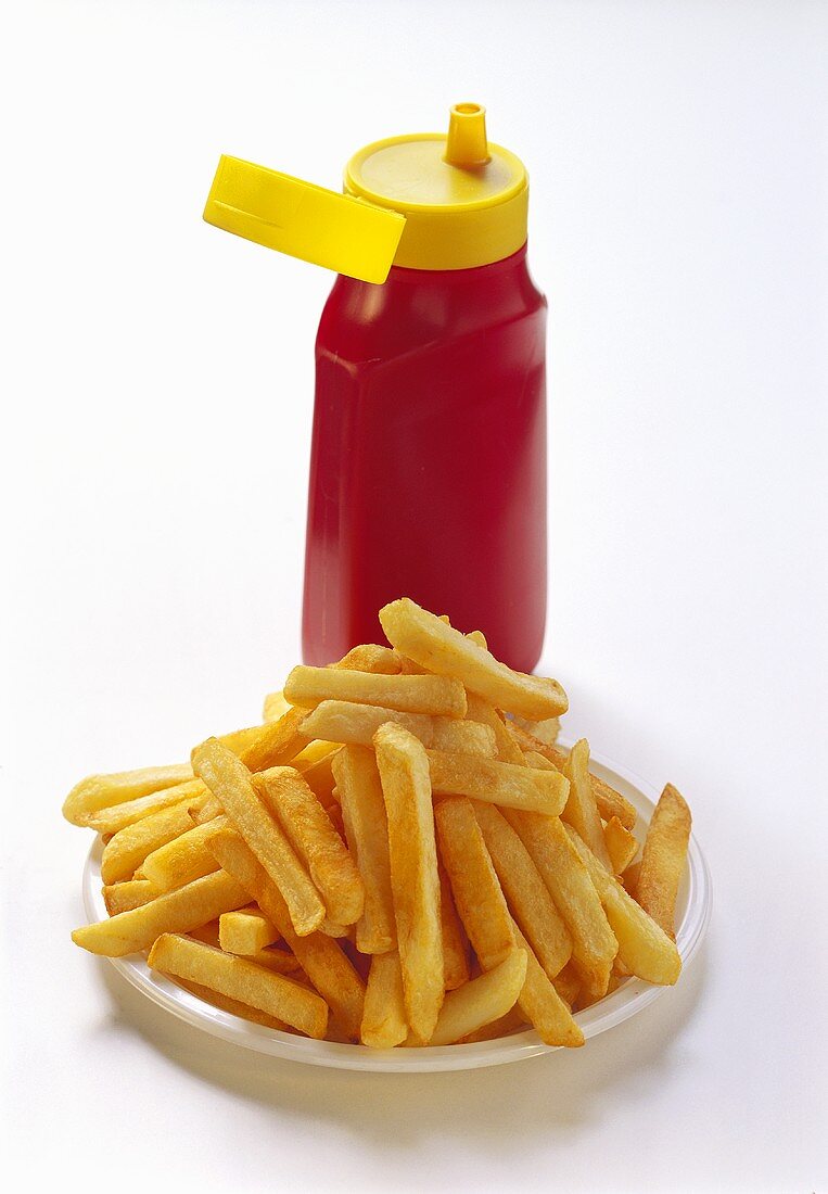 Chips on plate in front of a bottle of ketchup