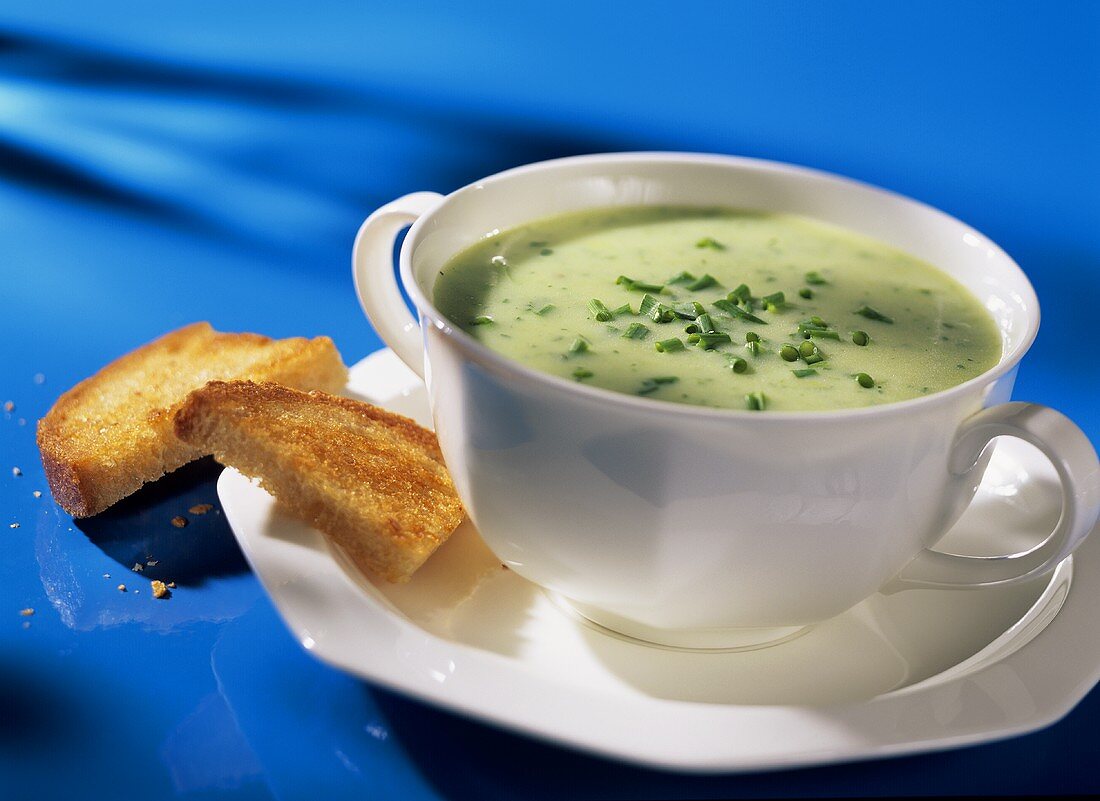 Cream of leek soup with snipped chives in soup plate
