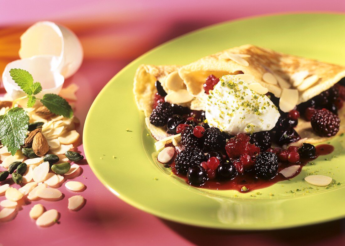 Crepes mit Beerenfüllung, Sahne und Mandelblättchen