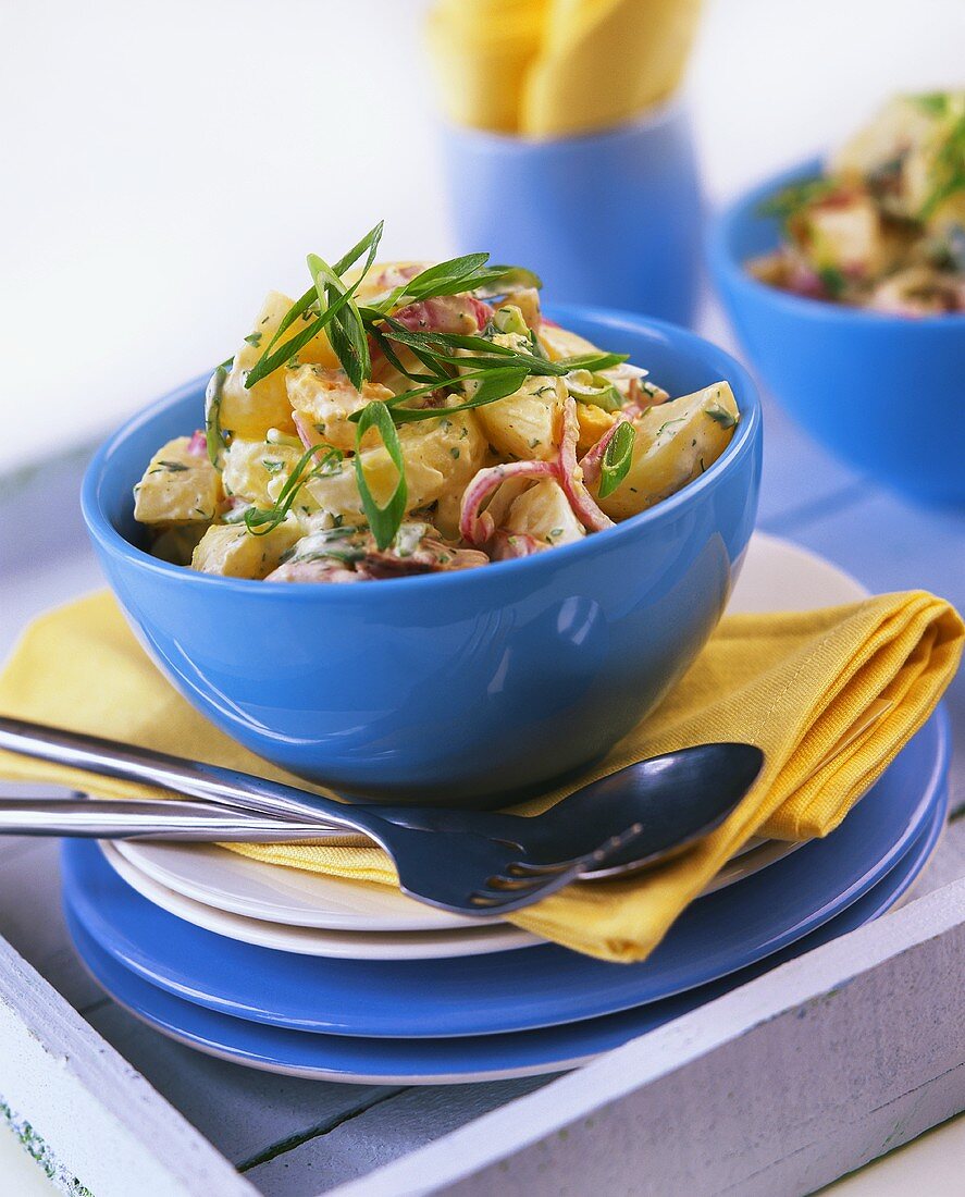 Potato salad with onions in a blue bowl