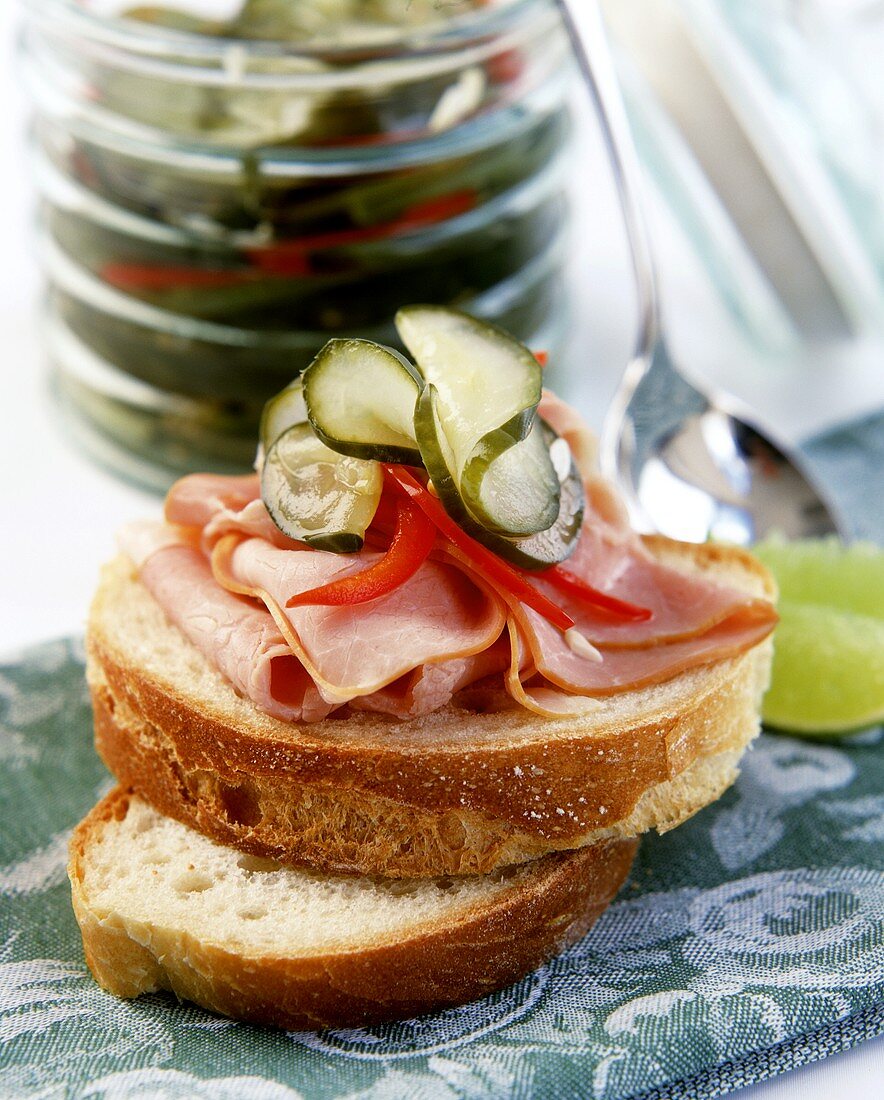Open white bread sandwich with ham and gherkins 