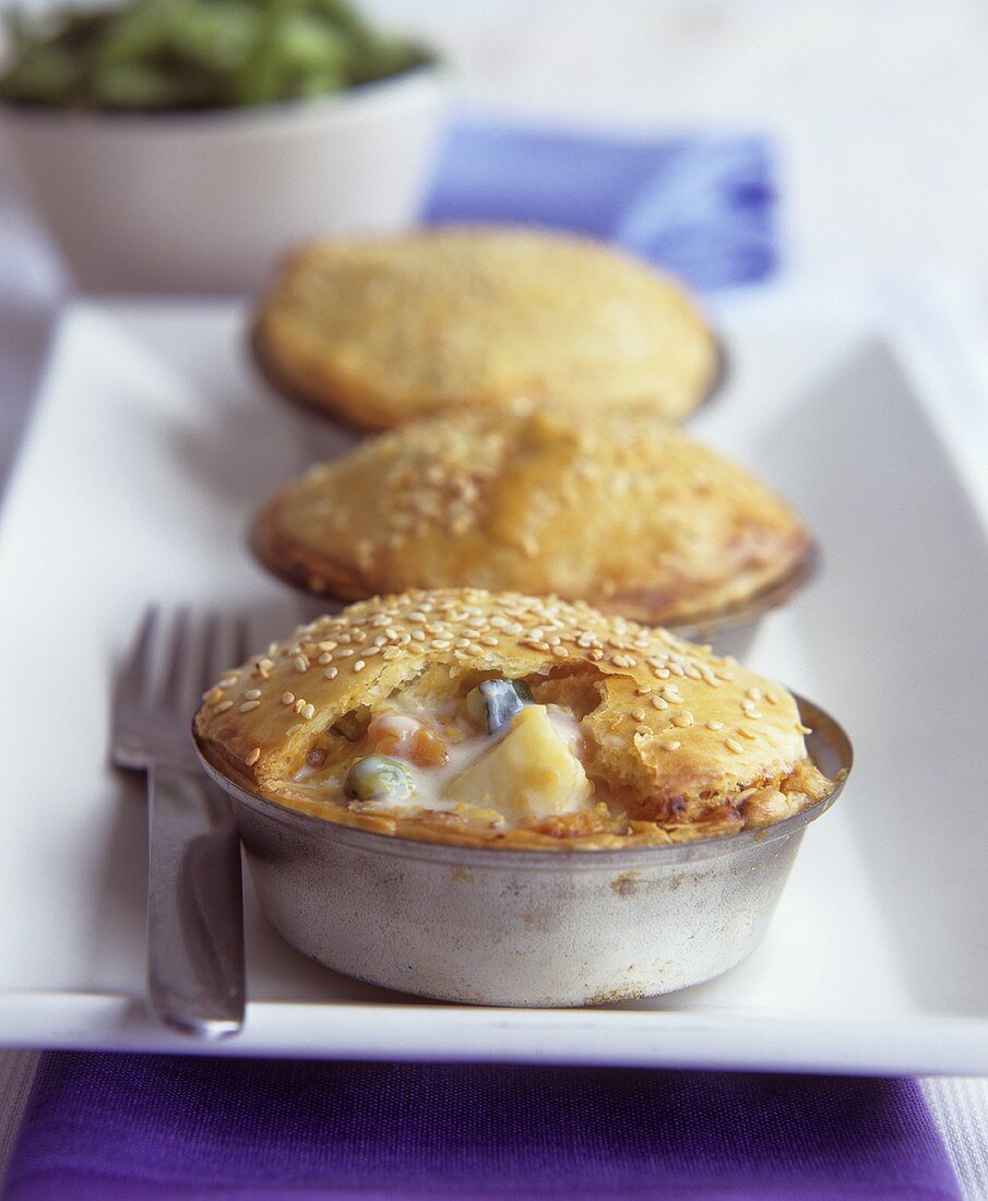 Small vegetables pies with sesame in the baking tins
