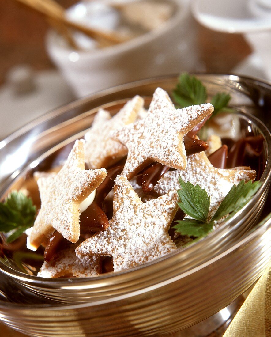 Star-shaped biscuits with icing sugar in metal bowl