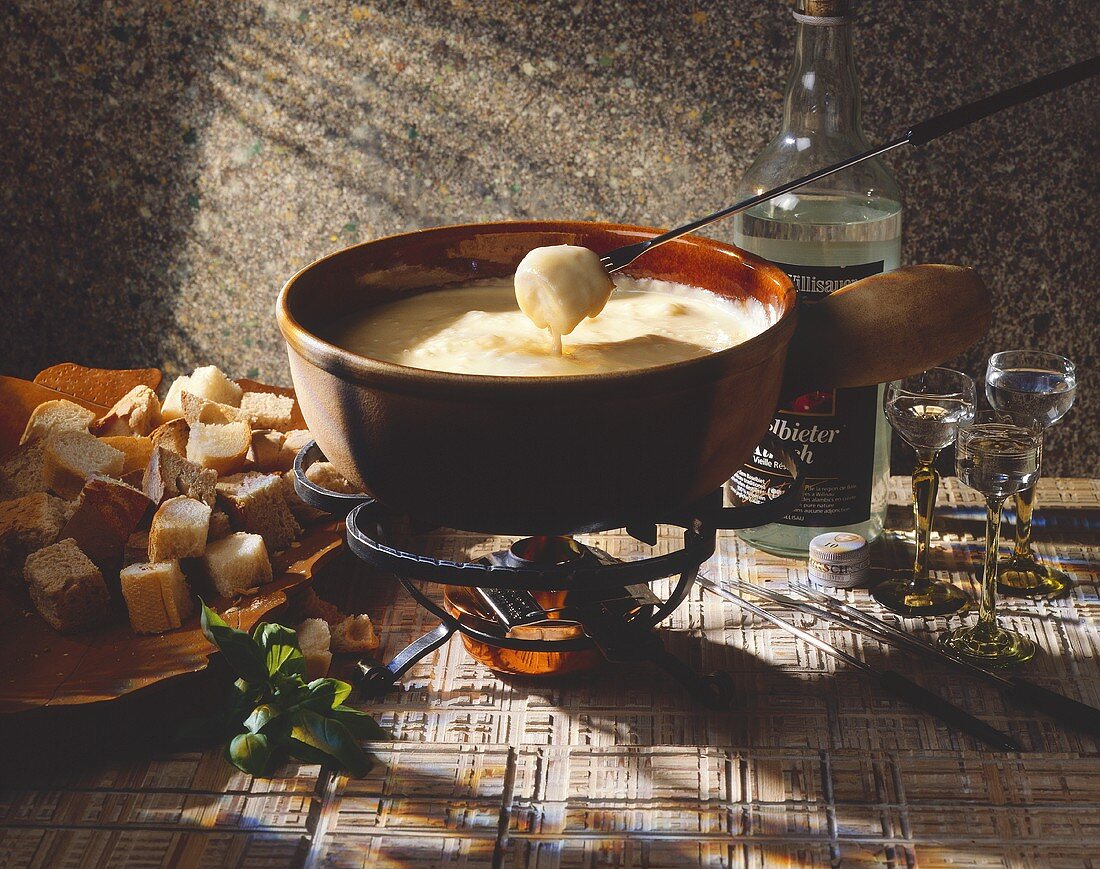 Cheese fondue with bread cubes and schnapps