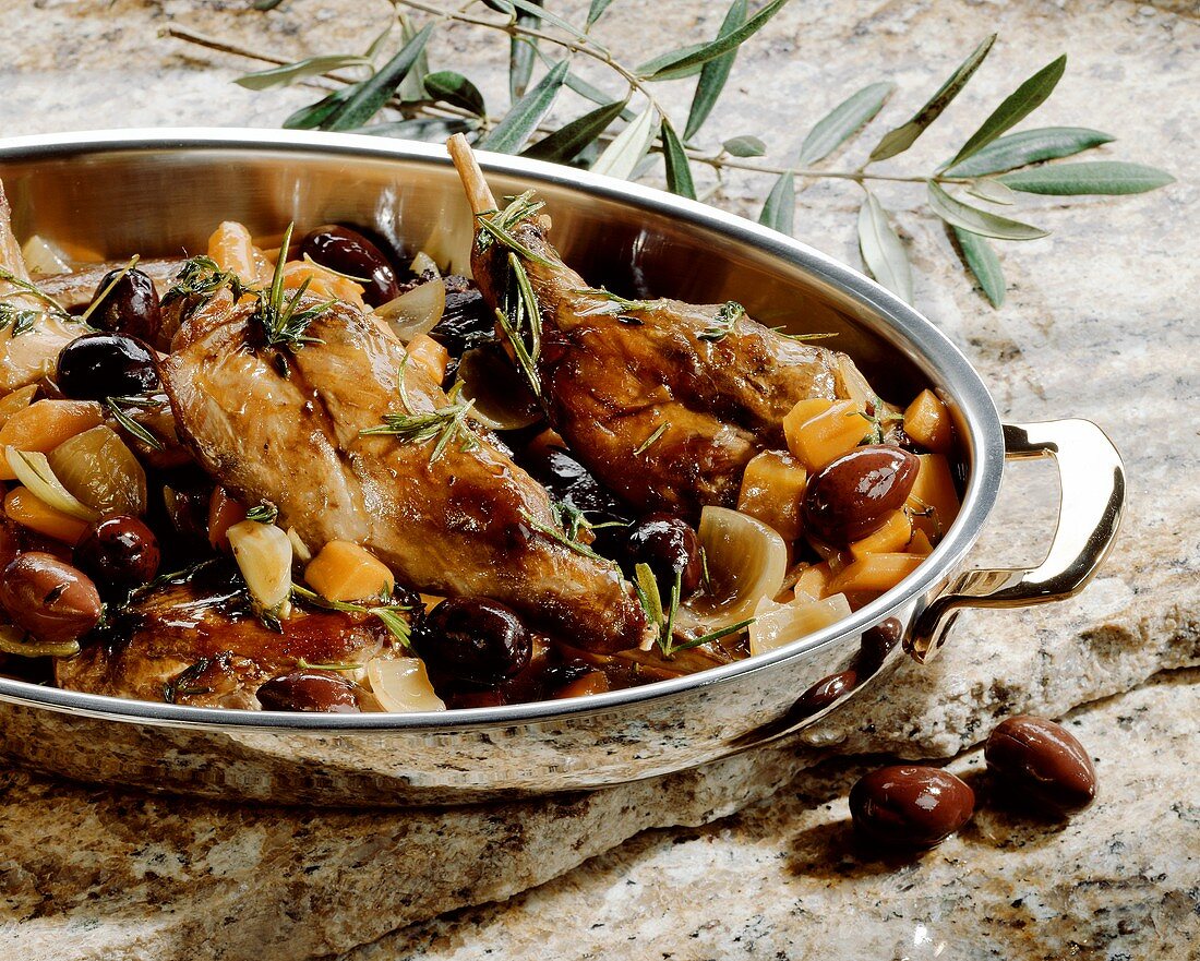 Rabbit with olives and rosemary in roasting dish